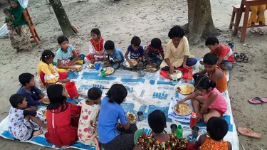 Schüler essen gemeinsam auf dem Boden